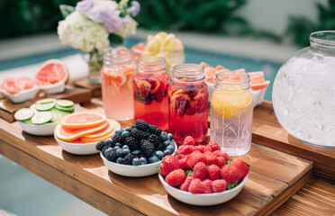 Refreshing summer drinks with fresh fruits and berries by the pool