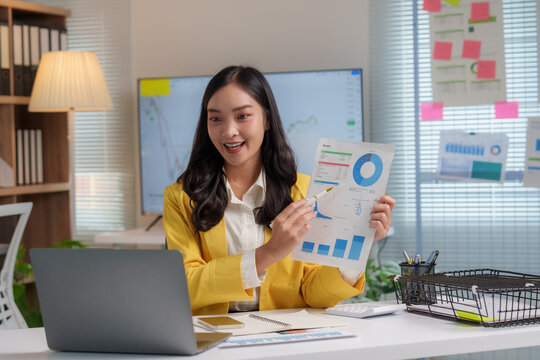 Asian businesswoman showing financial charts during video call in office