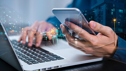 Person using laptop and smartphone with city lights overlay technology business