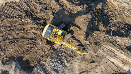 Aerial, overhead image of a excavator working on construction site moving dirt, earth.  Earthmoving, excavations, digging on soils  © Thomas