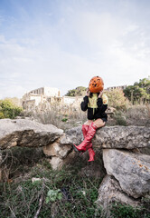 Halloween Pumpkin Head Girl in Urban Graffiti Scene with a red balloon.