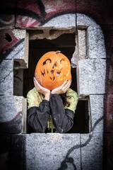 Halloween Pumpkin Head Girl in Urban Graffiti Scene with a red balloon.