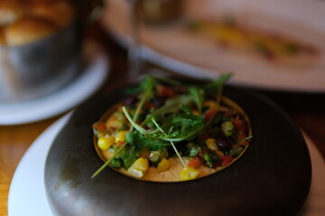 scrambled eggs with arugula Eastern European cuisine presents scrambled eggs with smoked ham, parmesan and chives on toasted bread with tomato sauce, decorated with arugula and cherry tomatoes