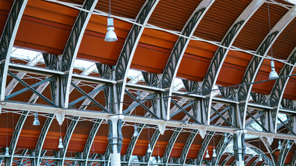 Historic London railway station roof with iron beams, cultural landmark
