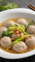 Bakso meatballs close-up in a rich broth with fresh green celery and fried shallots, high-resolution, appetizing and vibrant, food magazine style