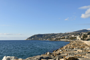 View of the bay from the rocky shore, with the promontory of Capo Nero in the background, on a sunny winter day, Sanremo (Imperia), Liguria, Italy