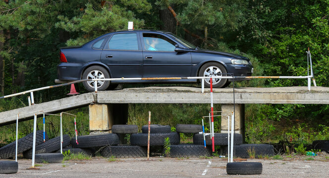 Car practicing maneuverability on obstacle course under clear sky in a parking lot - Powered by Adobe