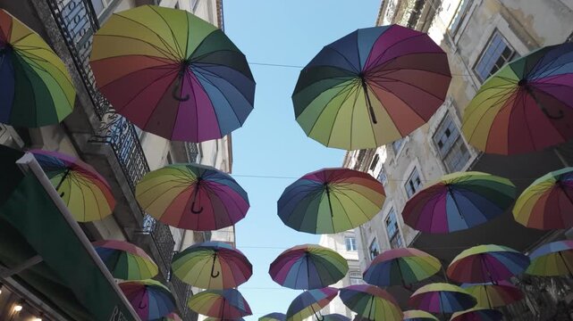 Colorful rainbow umbrellas hanging over a street in Lisbon