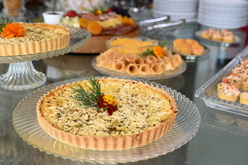 cheese quiche, gourmet charcuterie and cheese board, elegant appetizer platter with fruit, sophisticated rustic catering display