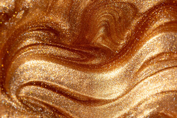 Glowing golden shimmering cosmetic texture of gel or body spray. Background texture for backdrops or mapping.