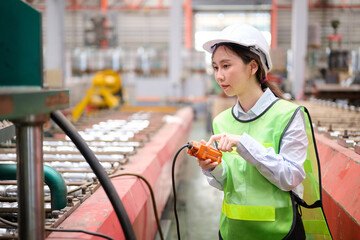Engineer or worker operating remote switch to control machine in the factory