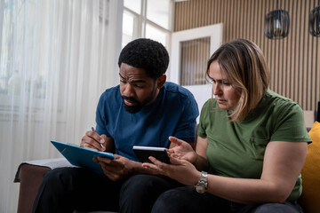 Mixed race couple stressed about household finances, rising food and housing costs, woman angry over powerless husband	