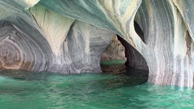 Glide through the enchanting Marble Caves of Lago General Carrera in Patagonia at sunrise. Witness the stunning reflections and natural beauty.