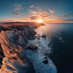 Stunning sunset over rocky coastline with ocean waves crashing.