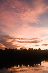 Tranquil Village Landscape of a Sunset Over a Lake Near Wenchang City with Tree Silhouettes