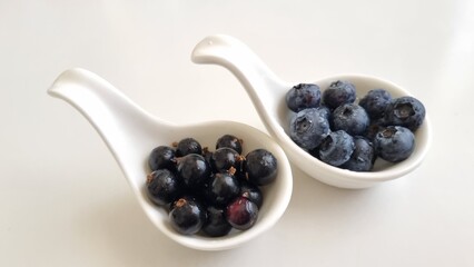 Mixed berries in white fruit, blueberry, blackcurrants in bowls. Healthy eating concept. Top view. Collection of berries in white bowls, isolated on white background with copy space for text.