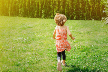 girl running away in the garden in summer