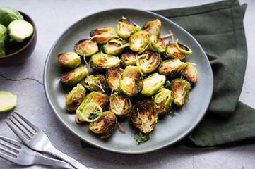 Plate of roasted Brussels sprouts paired with fresh, halved green ones.