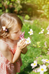 5 year old girl in the garden smelling flowers top view