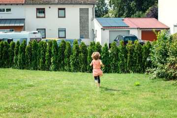 girl running in the garden in summer. childhood walk