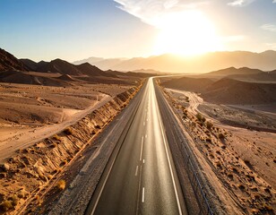 Naklejka premium High-angle view of a highway stretching through a desert landscape at sunset (2)