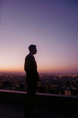 Fototapeta premium A modern and sleek silhouette of a businessman gazing over a bustling cityscape. A powerful representation of ambition, leadership, and progress.