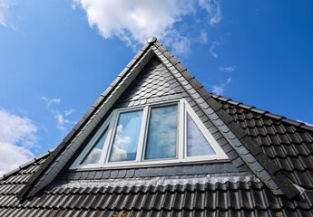 Dormer Window with Slate Roof Tiles against Blue Sky