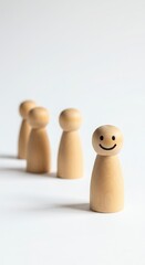 Obraz premium Minimalist wooden peg figures with smiling face against white background. Playful yet simple wooden figurines in clean arrangement. Cheerful wooden peg doll among neutral counterparts.