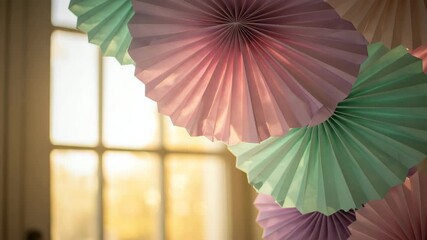 Colorful paper fans in pastel shades hang gracefully, enhancing the cheerful mood of the room