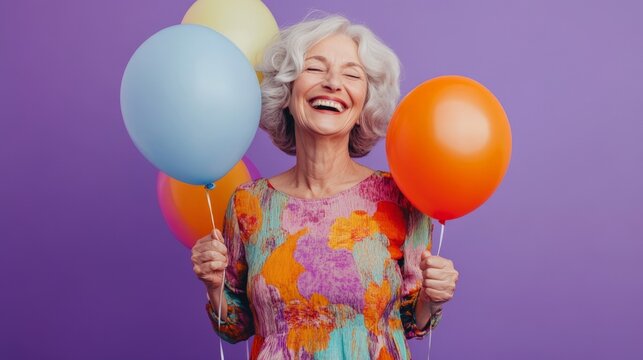 A woman is holding up a bunch of balloons and smiling. The balloons are in various colors, including blue, yellow, and orange. The woman's expression is joyful and happy - Powered by Adobe