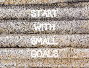 Start with small goals symbol. Concept words phrase Start with small goals on beautiful grey stone wall. Beautiful stone wall background. Business Start with small goals concept. Copy space.