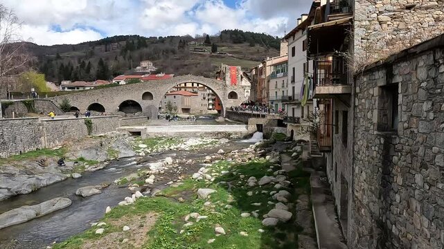 Girona, Spain - March 29, 2024. The river Ter passes through the medieval village of Camprodon with its ancient stone bridge. Girona, Spain