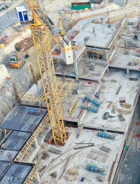 Aerial view of a construction site with a tall yellow crane dominating the scene amidst concrete structures and wooden frameworks, &Auml;&deg;stanbul, &Auml;&deg;stanbul, T&Atilde;&frac14;rkiye.