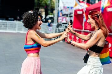 Two women dancing together at gay pride parade celebrating love and inclusivity