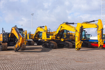 New yellow crawler excavators are parked on the site.