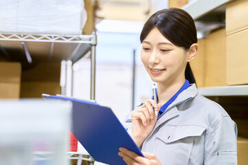 検品する作業員　棚卸しする女性社員　配達　運送　倉庫