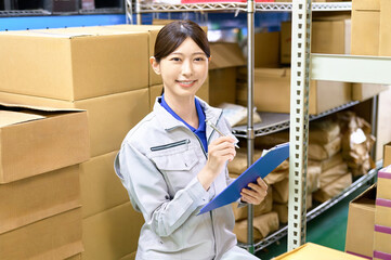 棚卸し　在庫管理する作業員の女性　運送　倉庫