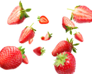 Yummy fresh strawberries swirling in air against white background