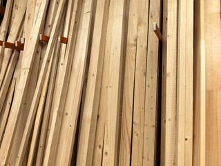 Stacks of smooth wooden planks ready for crafting in a well-lit workshop