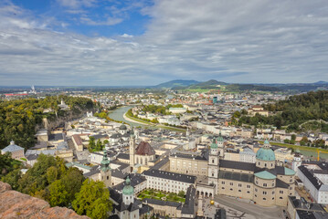 Salzburg, Austria: Elevated panoramic view of the historic city and surrounding mountains under a partly cloudy sky