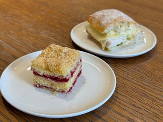 Sandwich and dessert on two white plates on wooden table. Food UGC photo, lunch simple eats at the cafe or home