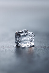 A glistening ice cube, subtly melting on a textured surface, evokes refreshment and purity. Perfect for representing cool drinks, modern design, or abstract concepts.