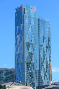 The CIBC Square tower features a blue glass facade with diamond-patterned lines and sharp vertical edges above nearby rooftops, Toronto, Canada