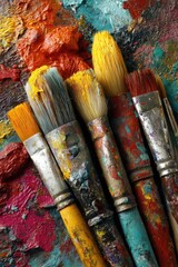 Fototapeta premium Close-up of used paintbrushes on a colorful palette