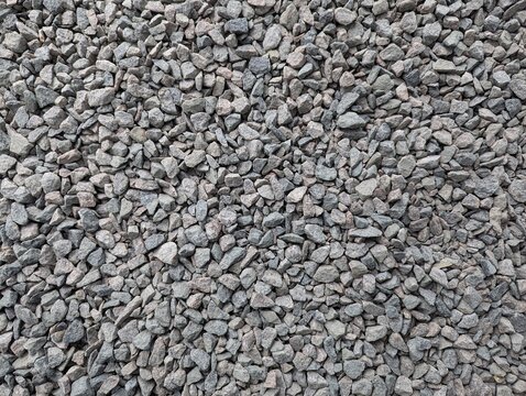 Granite gravel scattered on the ground creates a textured surface that invites exploration and imagination in a construction site