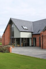Obraz premium This stunning contemporary home features expansive windows that let in natural light, surrounded by meticulously landscaped gardens.