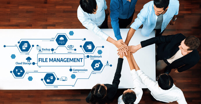A top-down view of a diverse team collaborating over a table, emphasizing file management concepts with technology icons, showcasing teamwork and efficiency. Amity - Powered by Adobe