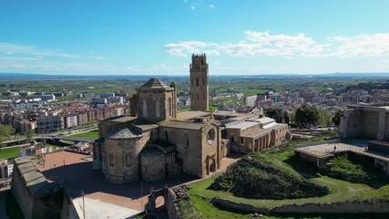 Aerial view of the Seu Vella Cathedral and Castell del Rei, with its detailed architecture, contrasting against the city skyline, Lleida, Spain.
