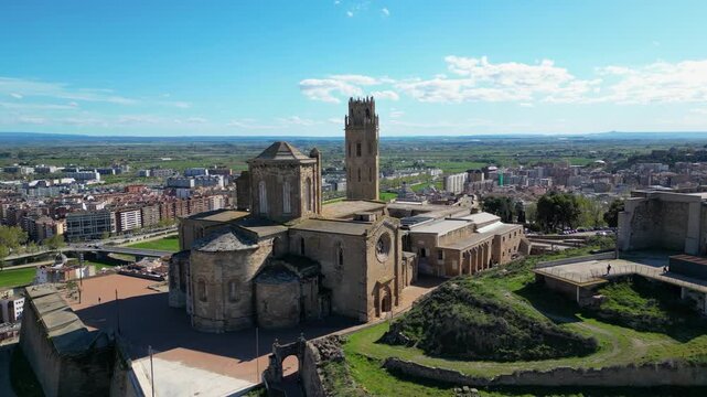 Aerial view of the Seu Vella Cathedral and Castell del Rei, with its detailed architecture, contrasting against the city skyline, Lleida, Spain.