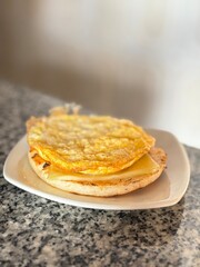 Arepa de maíz con queso y huevo encima